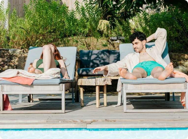 une homme et une femme prennent le soleil au bord d'une piscine