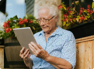 une femme agée utilise une tablette tactile