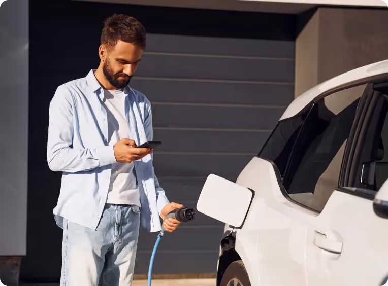 a man recharges his electric car