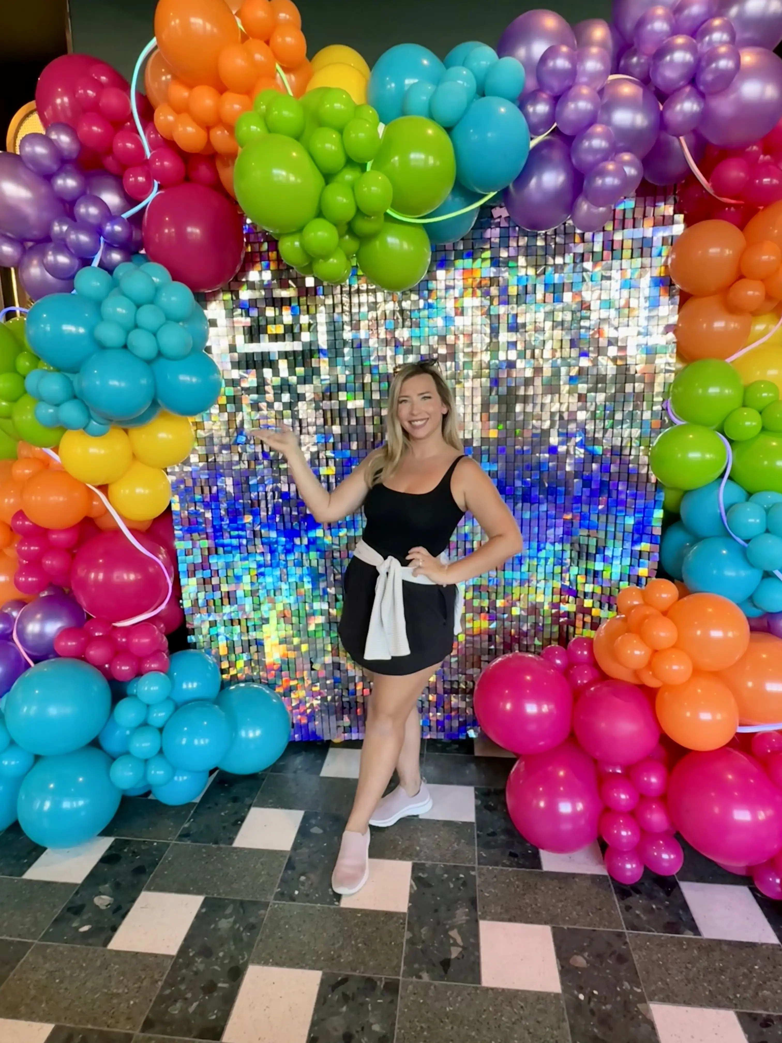 Jessica Donato posing in front of backdrop and balloon arch