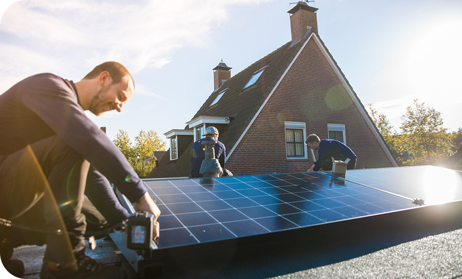 Installateurs op het dak van een huis die zonnepanelen installeren