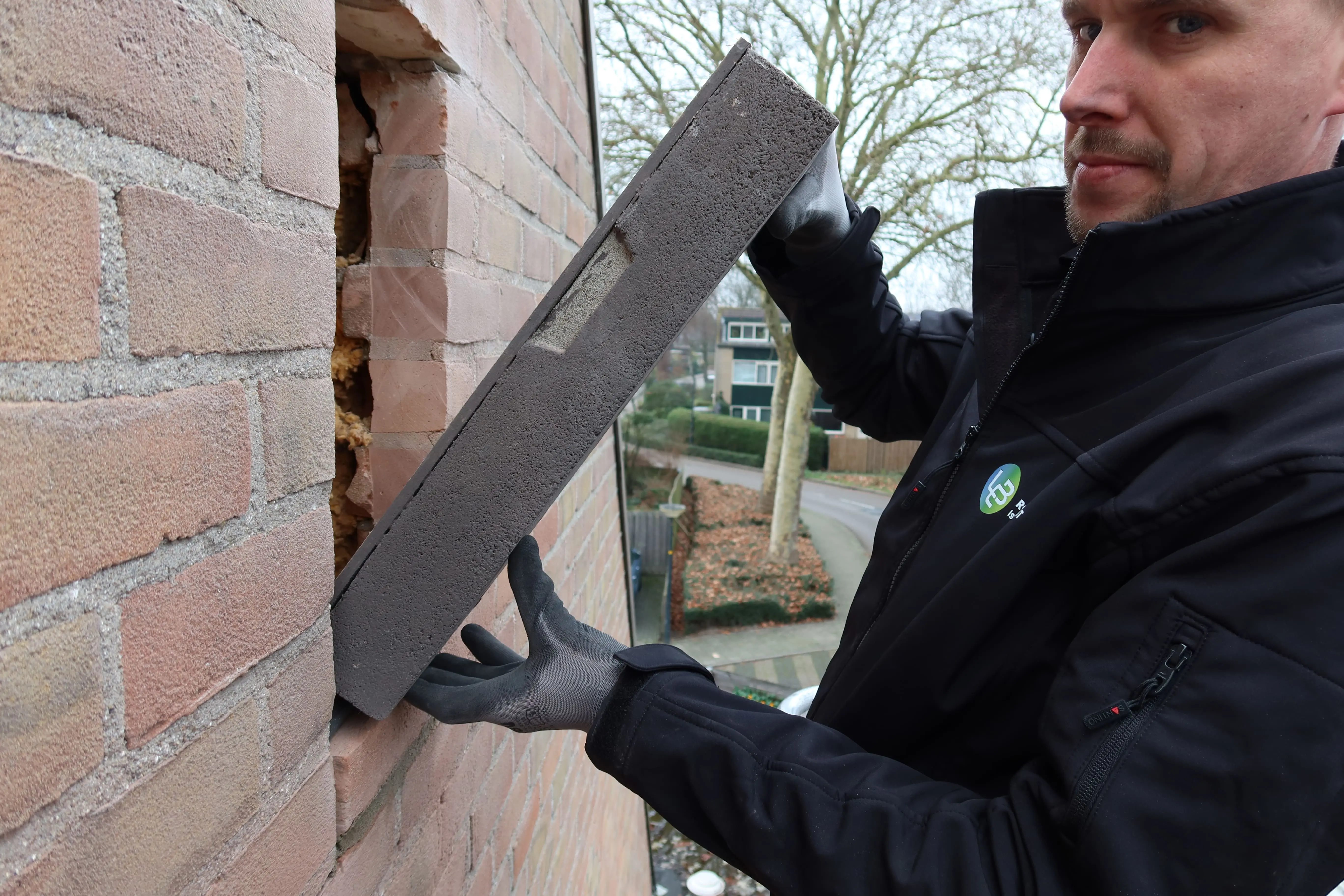 Werknemer brengt vloerisolatie aan in een kruipruimte.