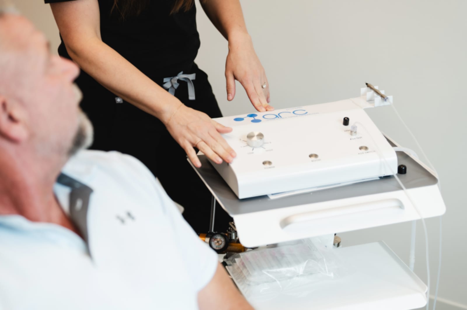 Close-up of dentist and patient examining dental model or treatment plan on light box