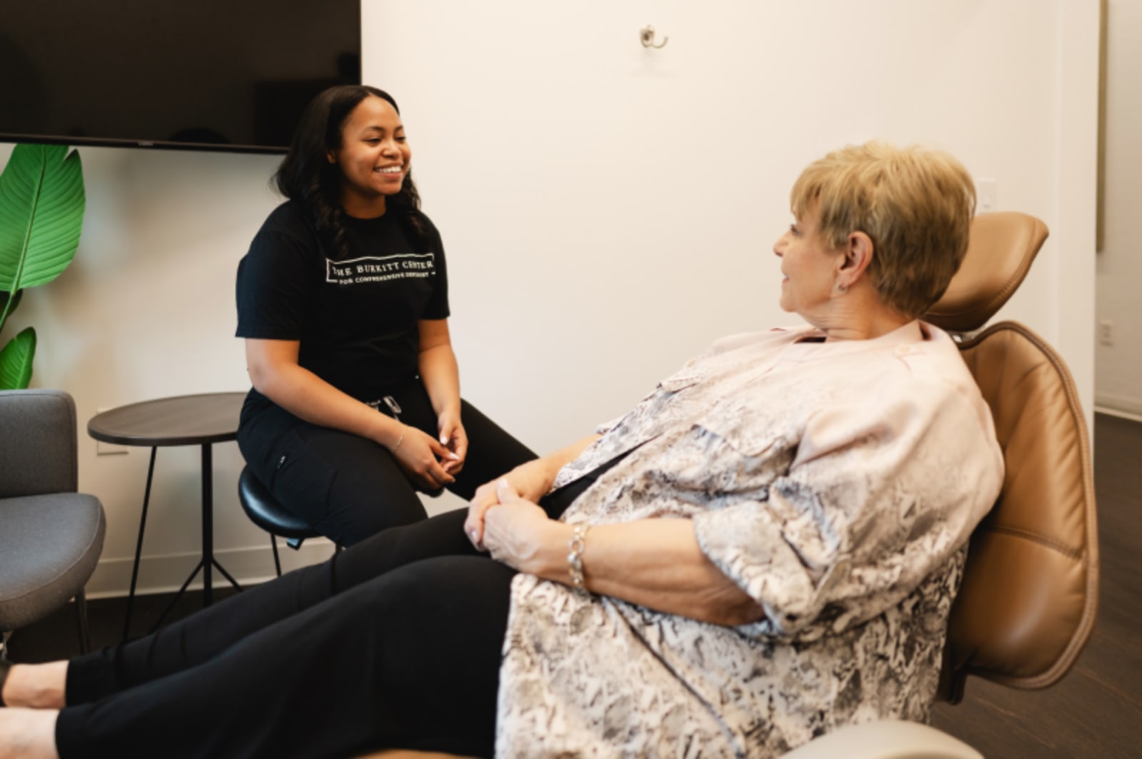 Dentist consulting with patient in treatment room discussing cosmetic smile options