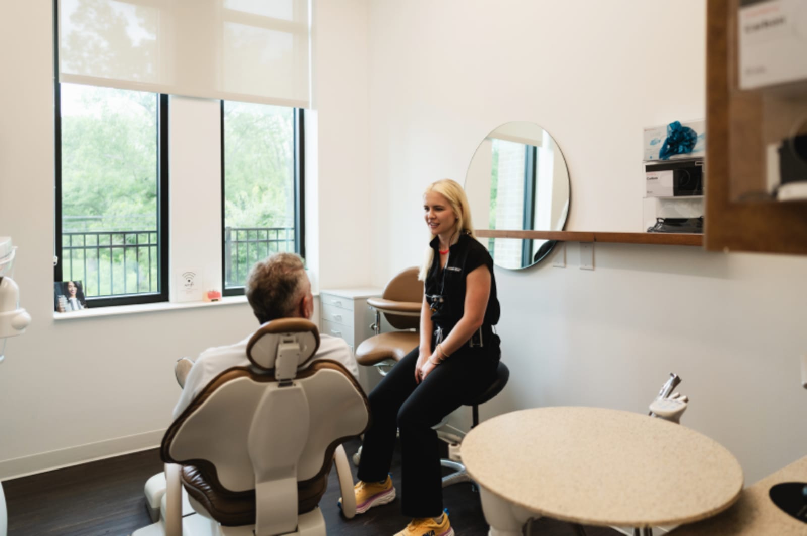 Dental hygienist performing a cleaning on a patient in a modern treatment room at Burkitt Center.