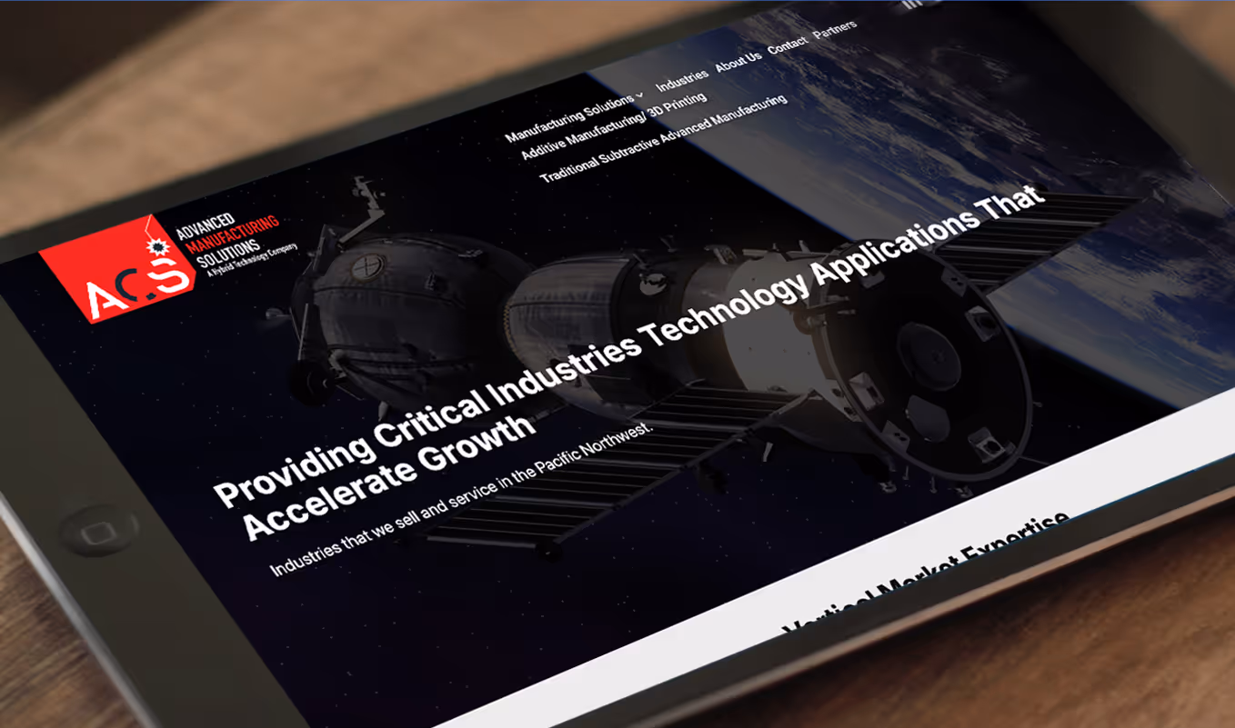Tablet displaying Advanced Manufacturing Solutions website with a space station image and text about providing critical industries technology applications.