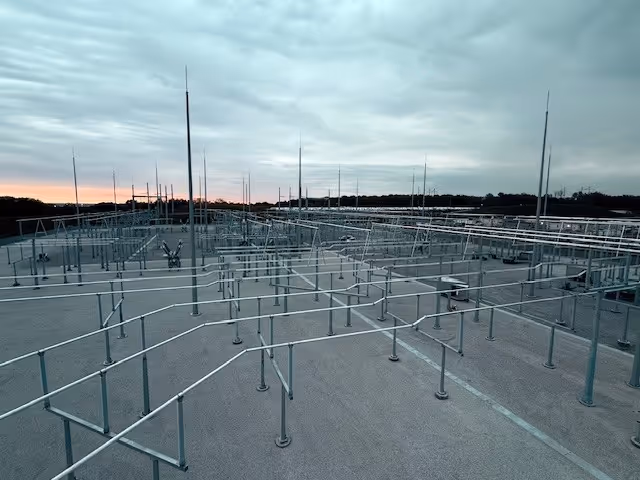 Outdoor electrical pipes under a cloudy sky during sunset.