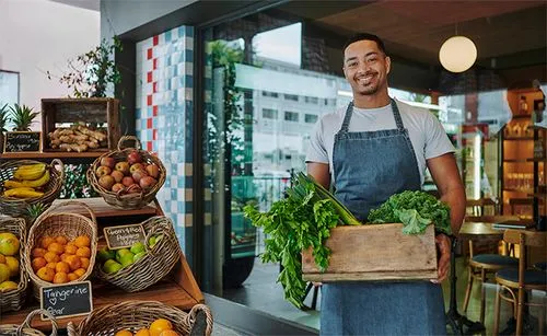 Mann hält Korb mit Obst in einem Lebensmittelladen