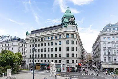 Historisches Gebäude in der Wiener Innenstadt mit beeindruckender Fassade und lebhafter Umgebung