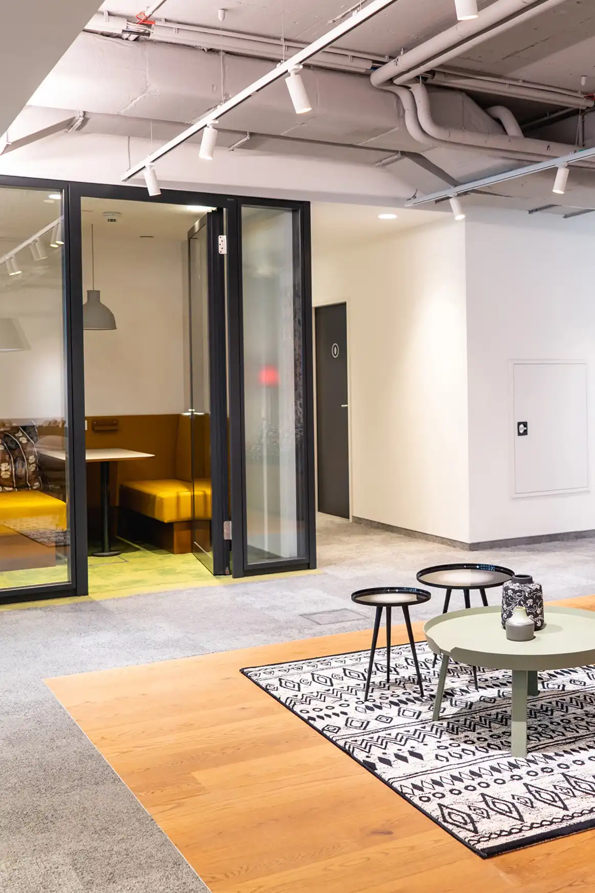 Immobilienfotografie einer modernen Bürofläche mit Sitzlounge, Glaswänden und stilvoller Wandgestaltung