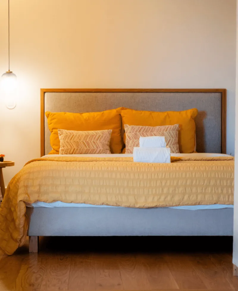 Bed with orange pillows.