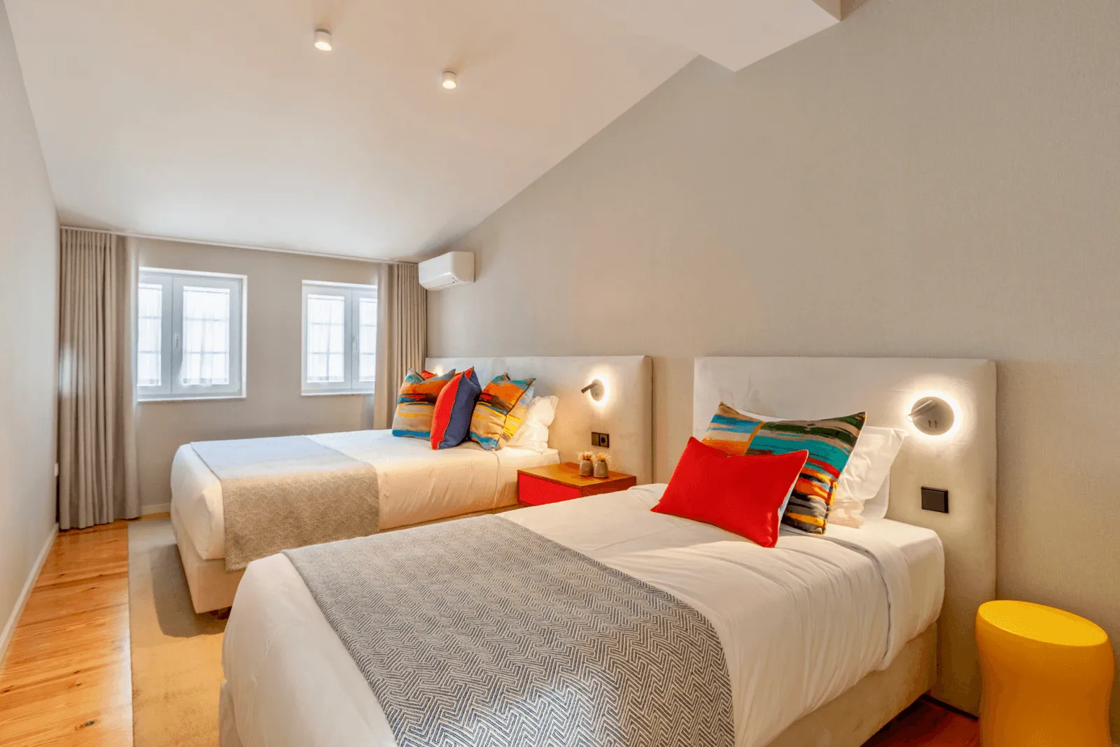 Bedroom with two beds with colorful pillows.