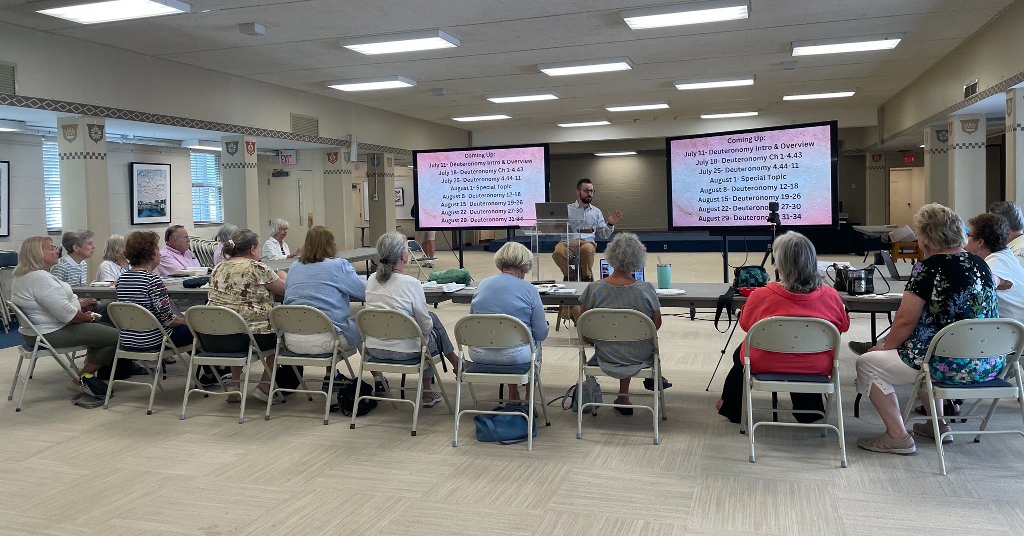 Group of people sitting at tables during a Bible class