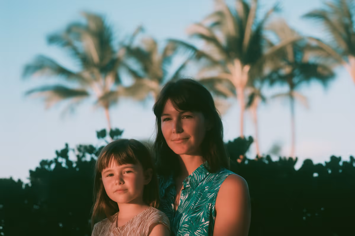 a mother and child in front with palm trees in the background