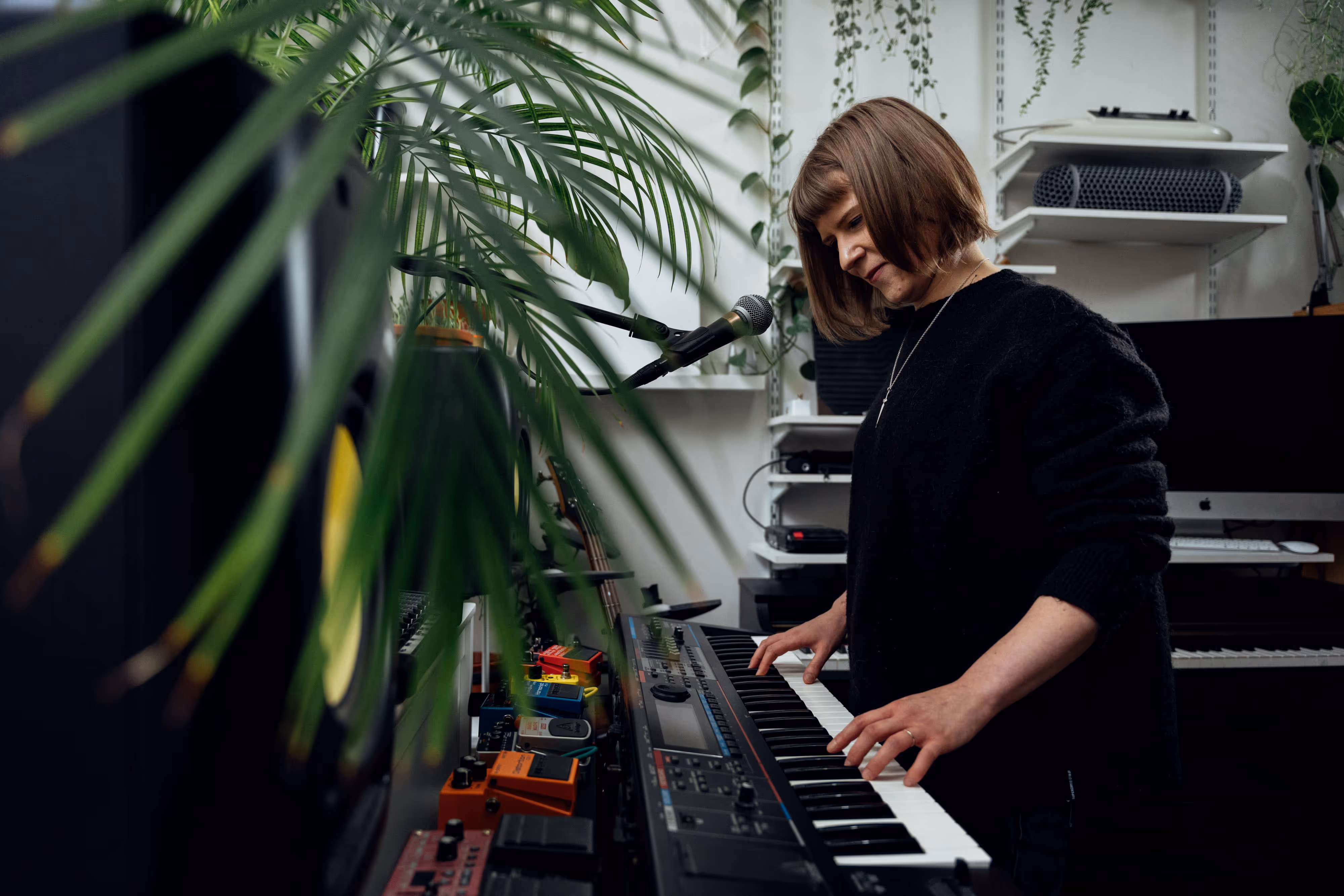 pianist shown in her studio surrounded by plants