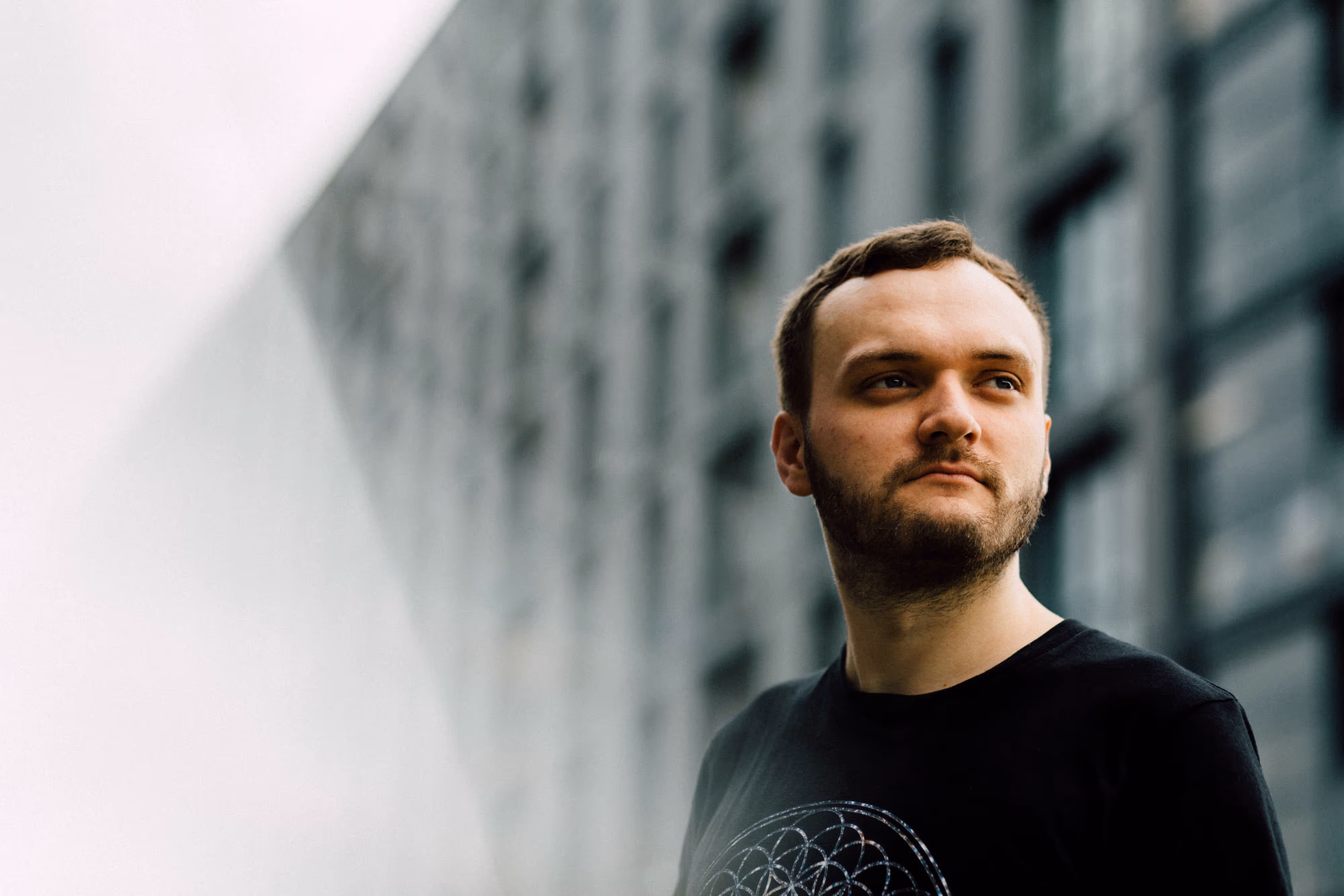 dj with grey building and leading lines in background