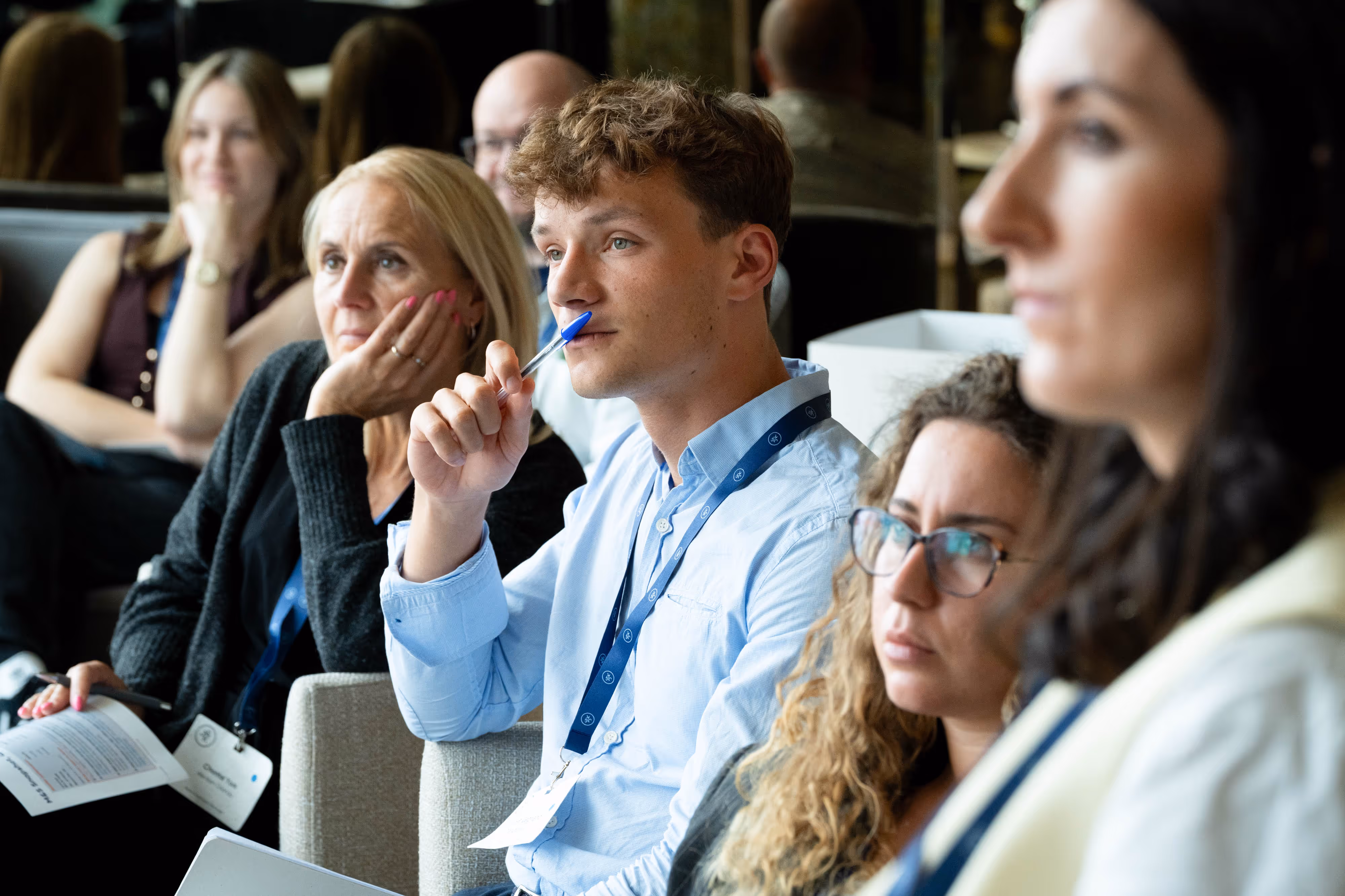 A group of people sit closely together, attentively listening during a conference or seminar held at Cloud23 in Manchester.