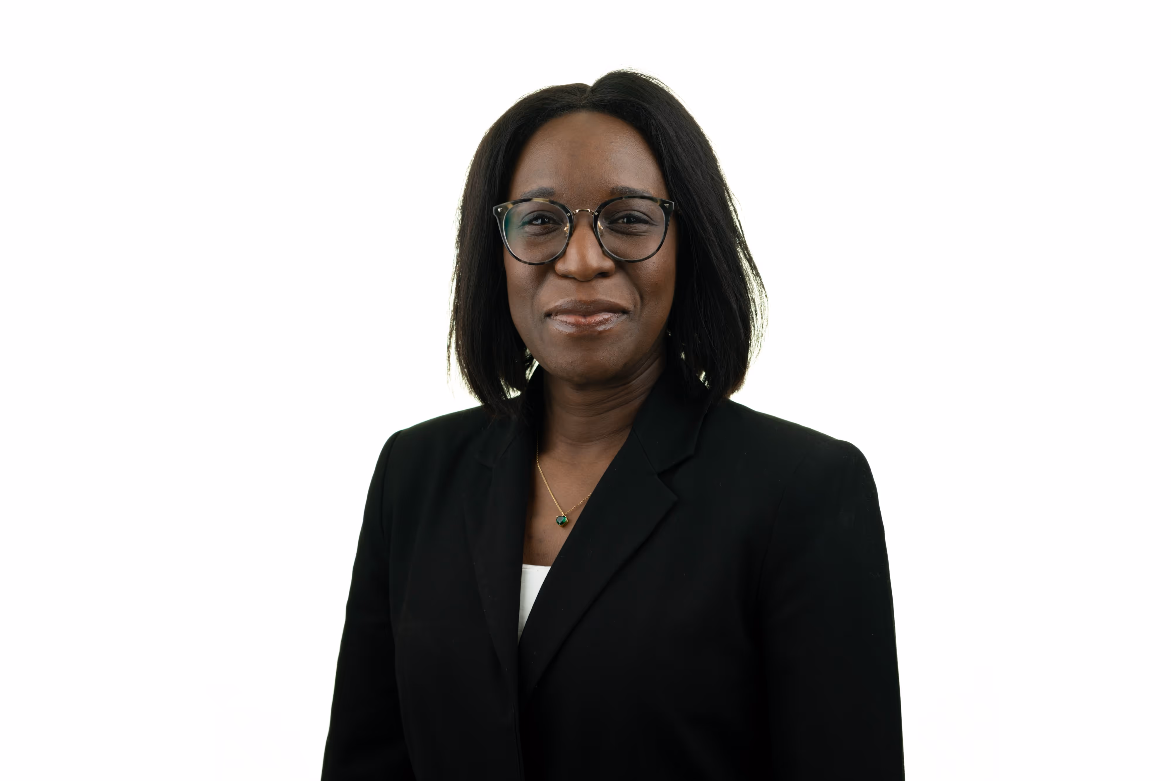 Solicitor with shoulder-length hair and glasses wearing a black blazer, smiling against a white background.