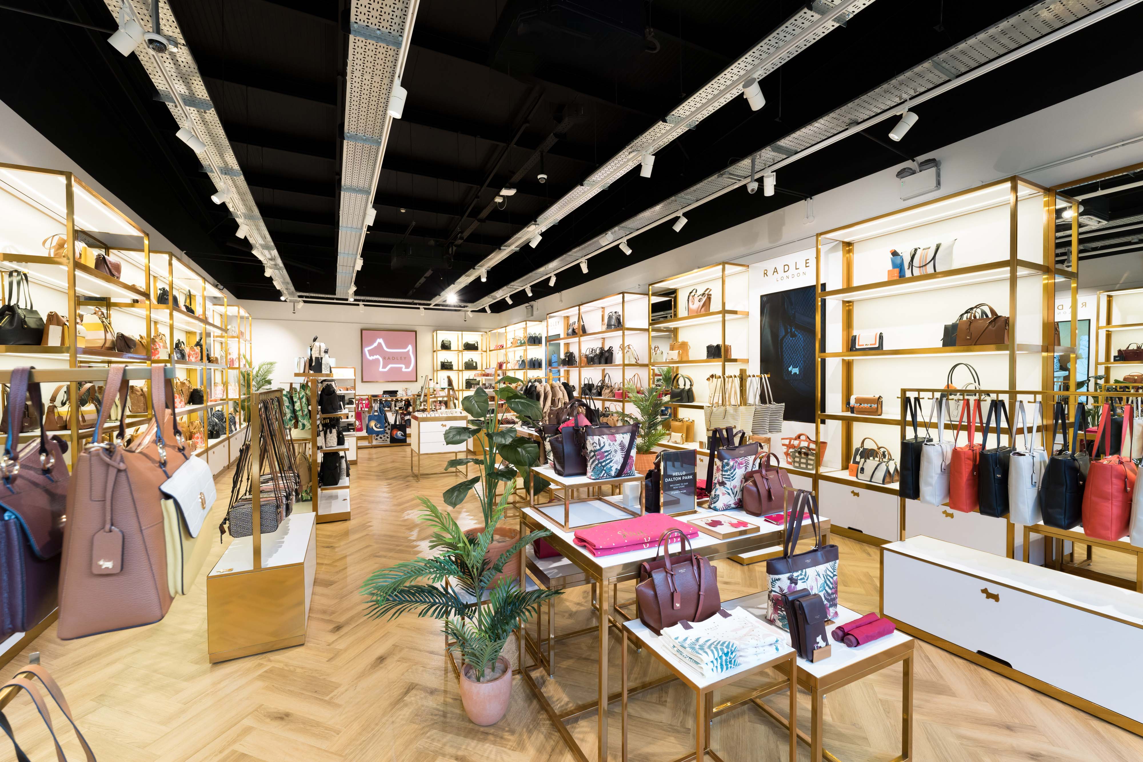 A modern handbag shop with shelves and displays filled with various purses and accessories.
