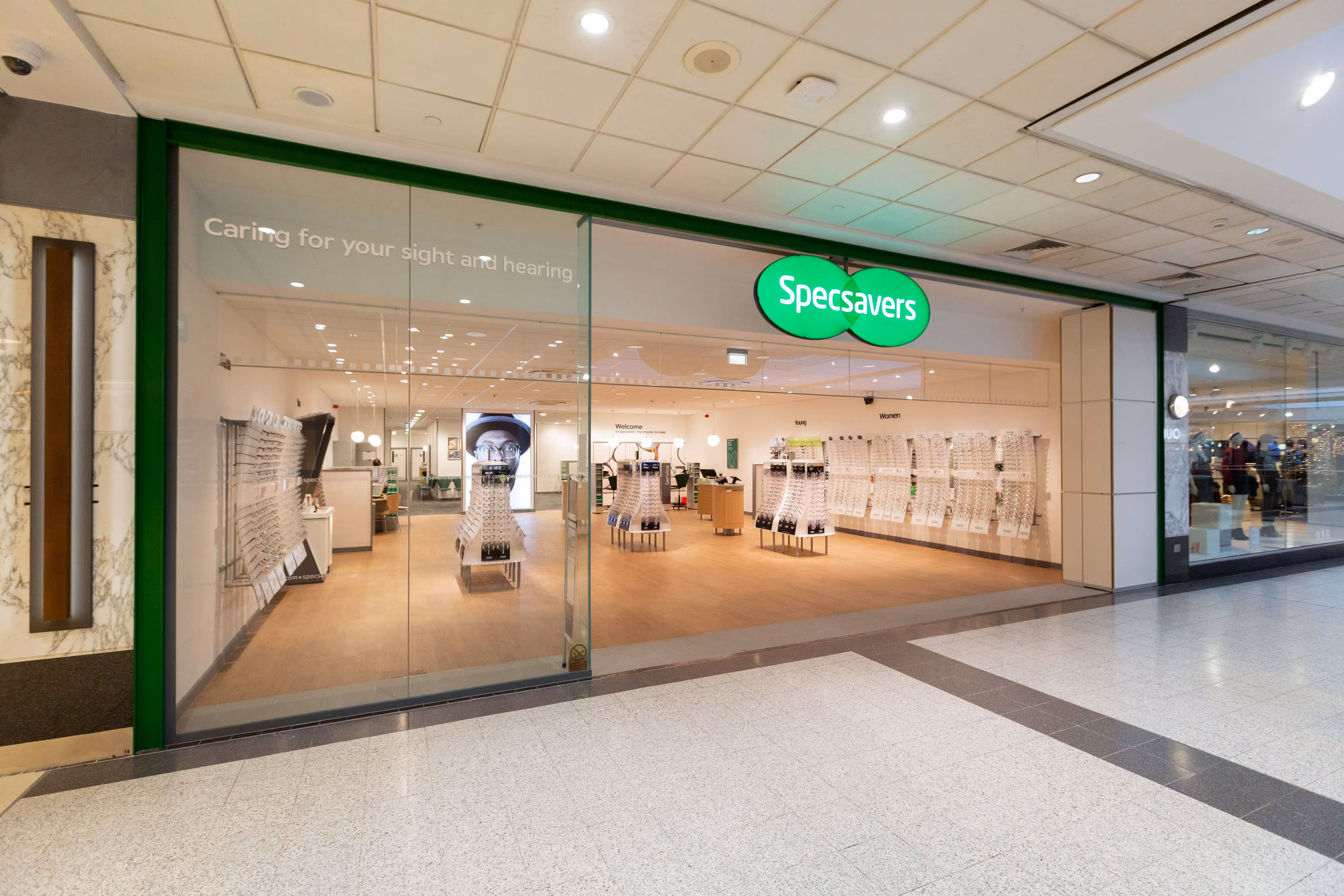 A Specsavers shop in Manchester Arndale shopping centre, with bright lighting and spectacles displays.