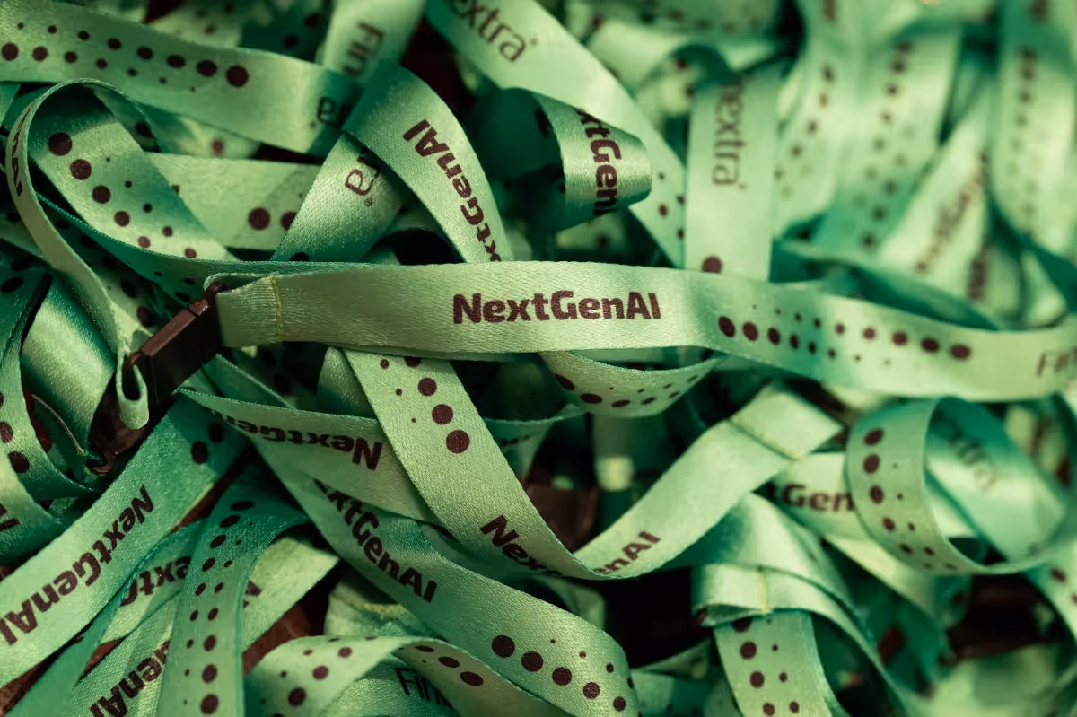 A close up photo of a pile of green corporate conference lanyards at an event registration desk.