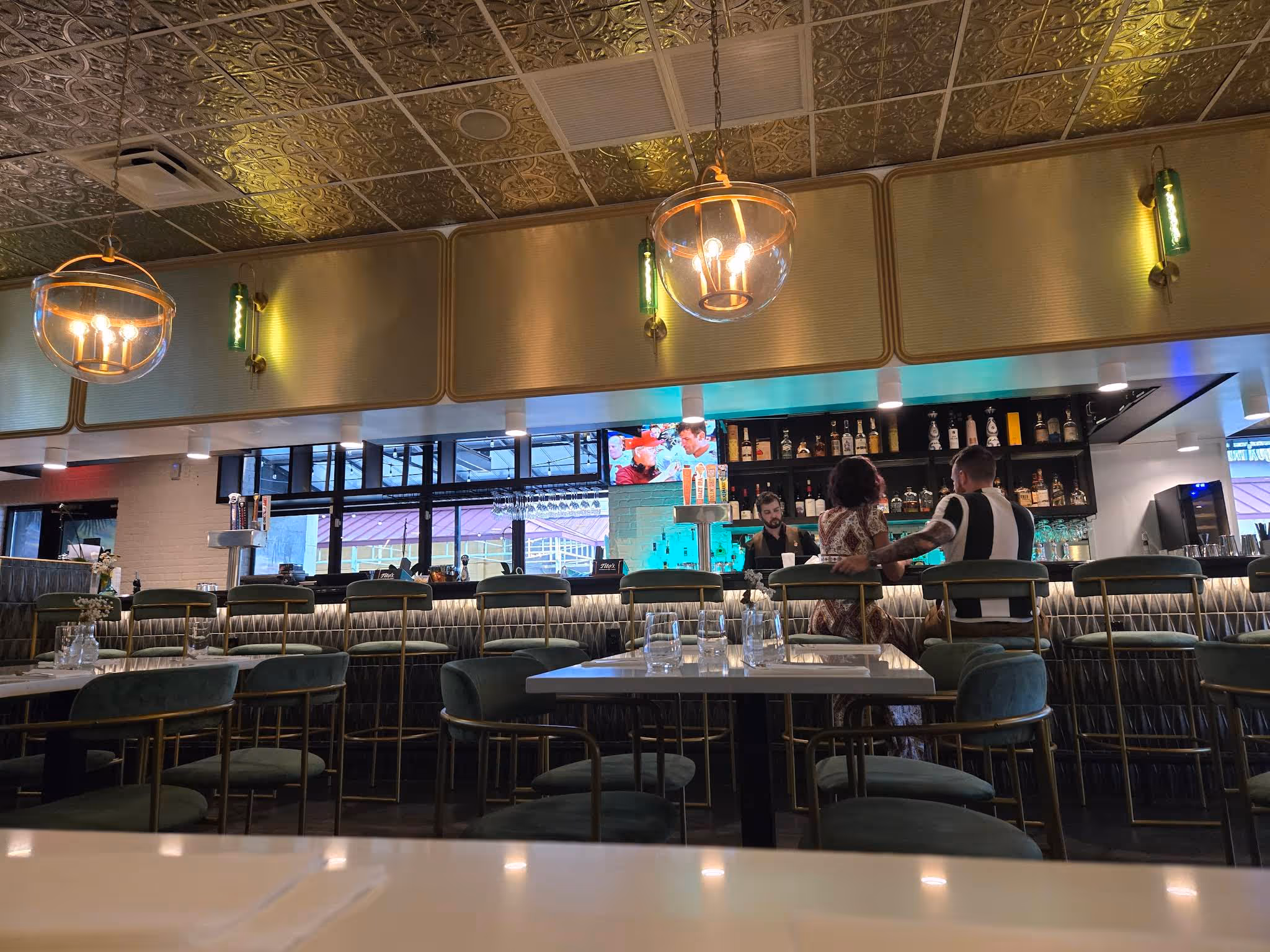 A restaurant with a bar and a large number of chairs.