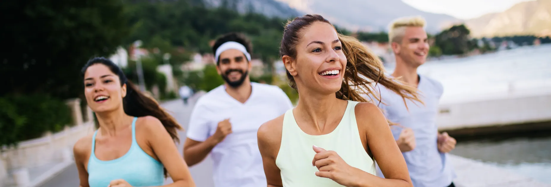 A group of people running along a river.