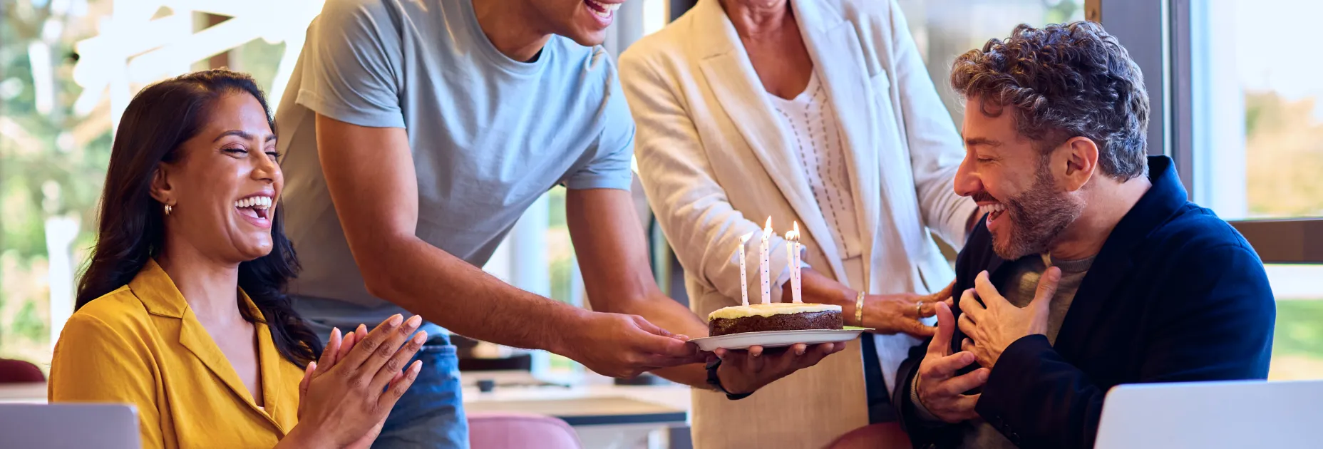 A group of people standing around a cake.