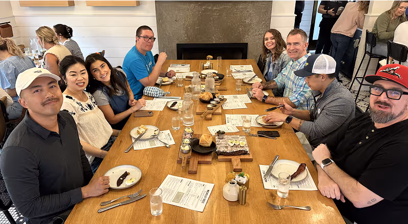 Large group gathered around a restaurant table enjoying a meal