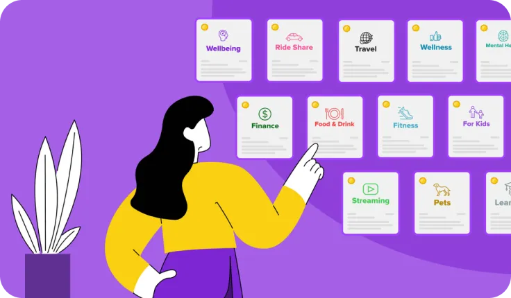 A woman pointing at a wall with a bunch of things on it.