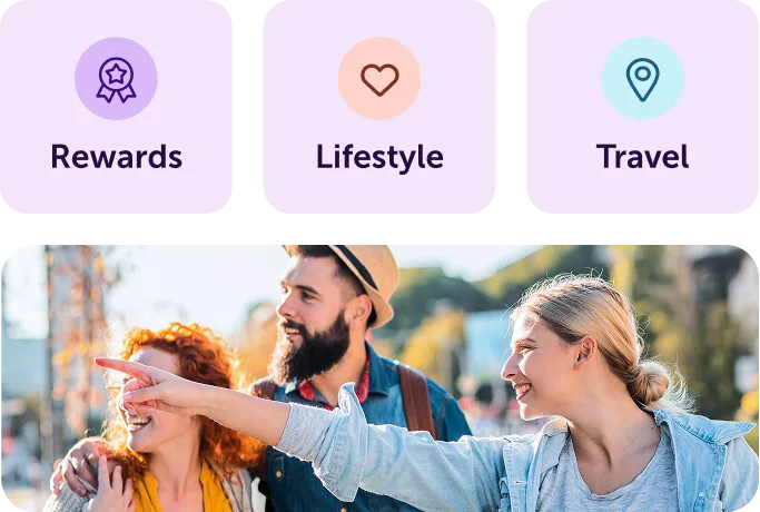 Three friends outdoors smiling; a woman points ahead while a man and another woman look on happily.