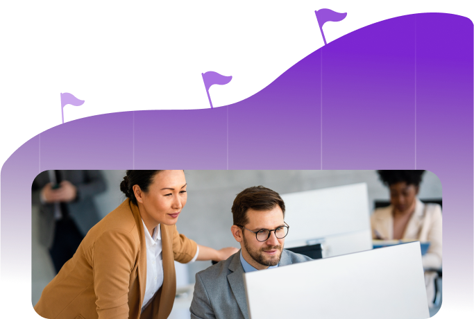 A woman in a brown jacket leans over a man in glasses who is seated at a computer, both focused on the screen, with a purple graph-like background featuring flag markers.