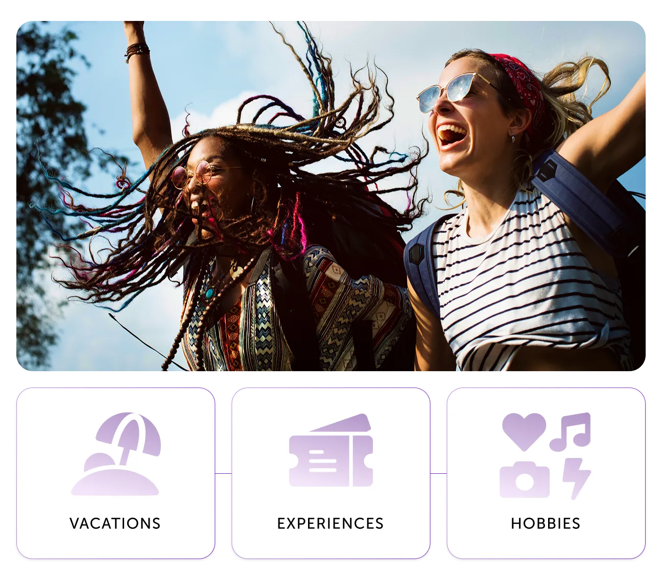 Two happy women with backpacks joyfully raising arms outdoors under a blue sky.
