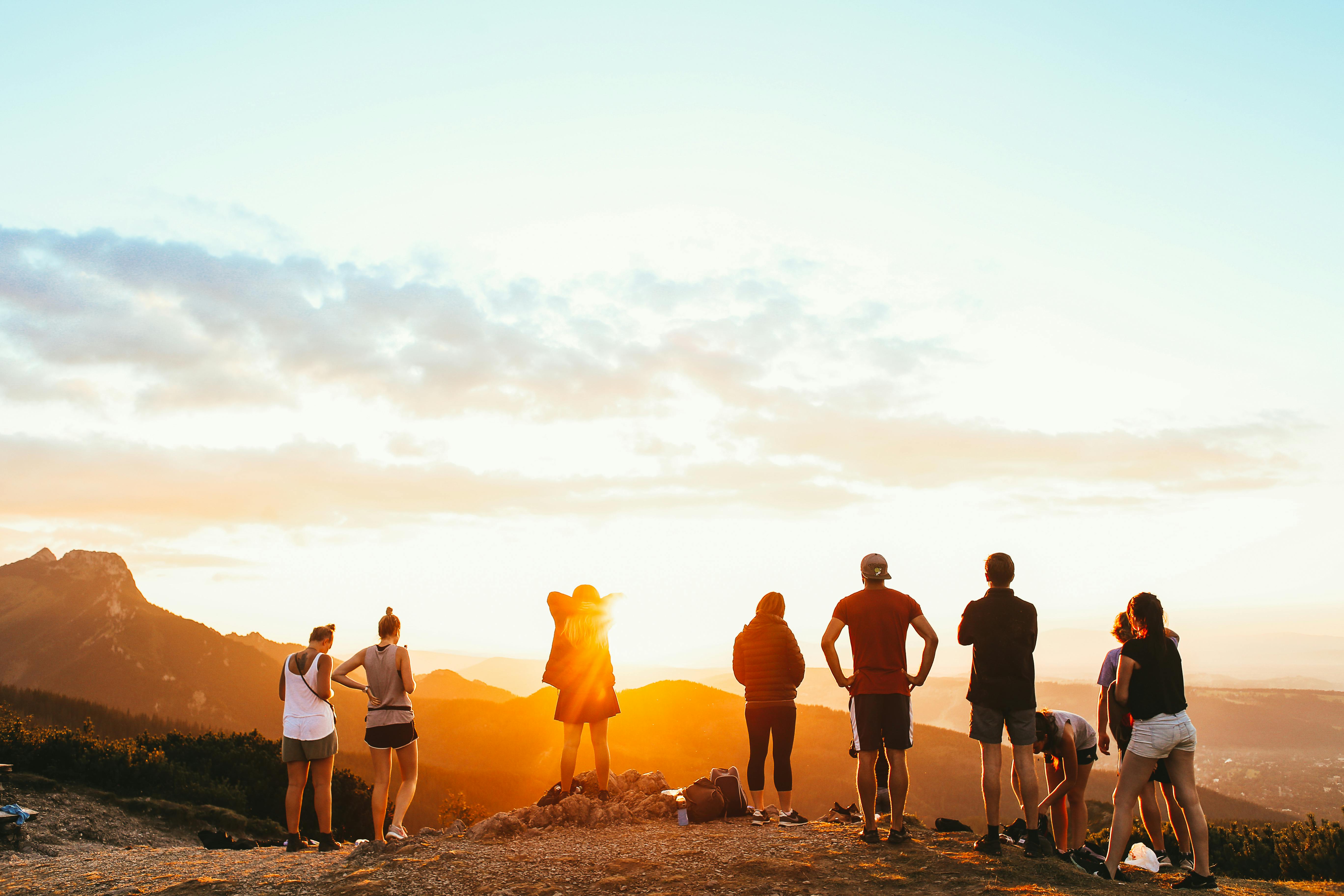 Group of solo travelers watching the sunset together