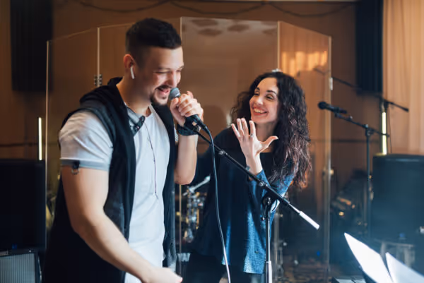 Séance de coaching vocal avec professeur et élève, micro professionnel et accompagnement personnalisé.