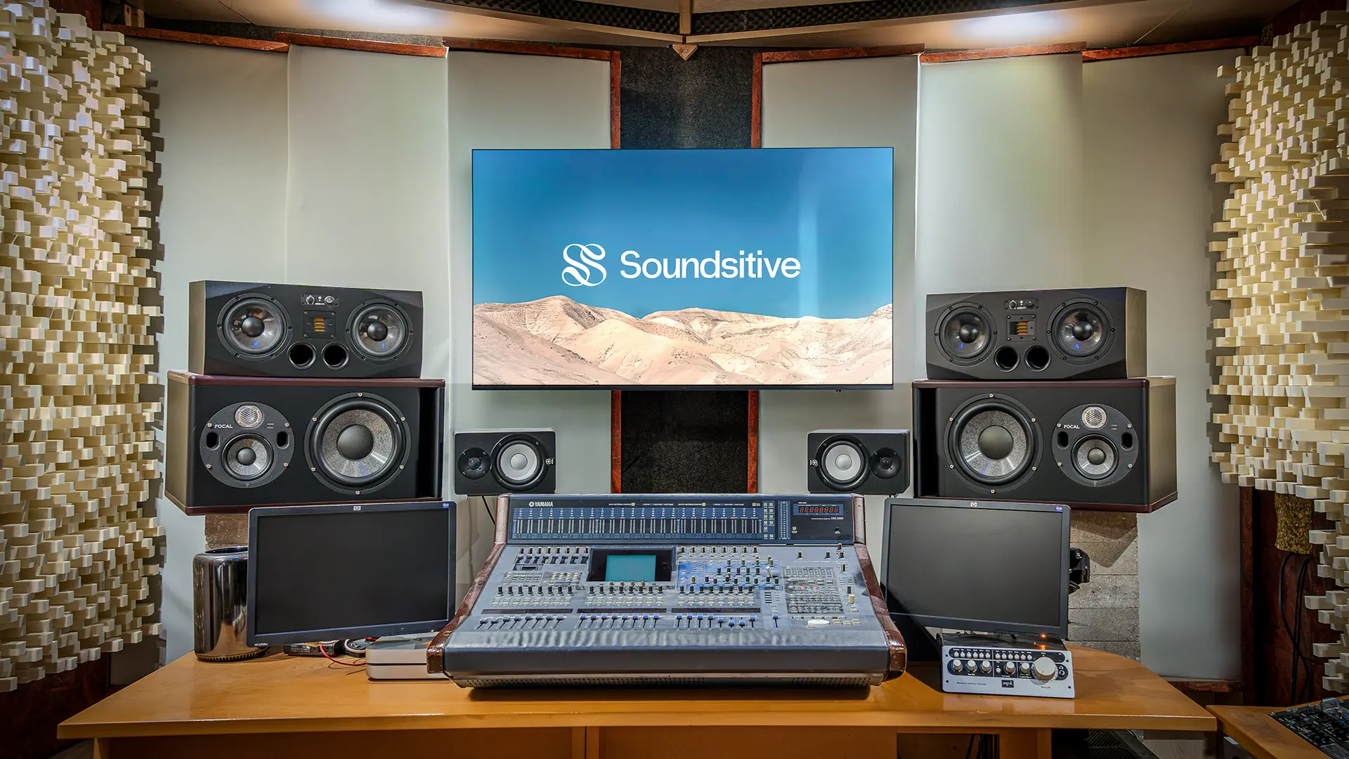 Studio d’enregistrement professionnel à Bruxelles avec console de mixage, enceintes de monitoring et panneaux acoustiques, offrant un espace de création sonore et visuelle de haute qualité.