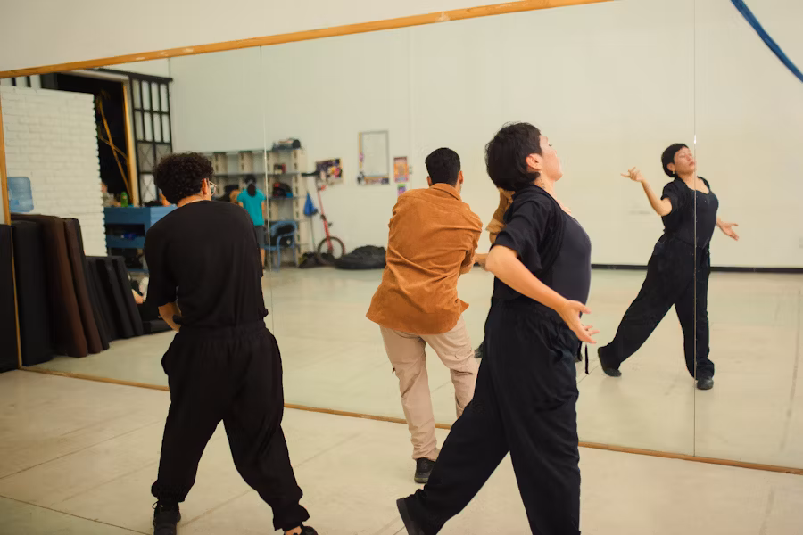 Séance de coaching scénique avec professeur et artiste, travail de posture et performance sur scène.
