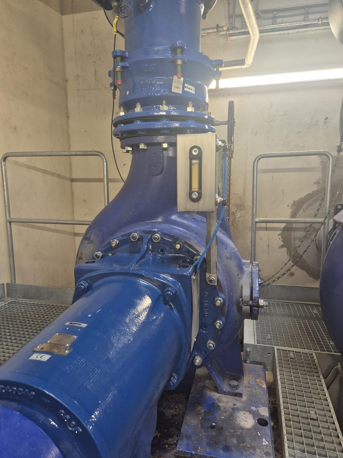 Blauwe gemaalpomp met leidingwerk