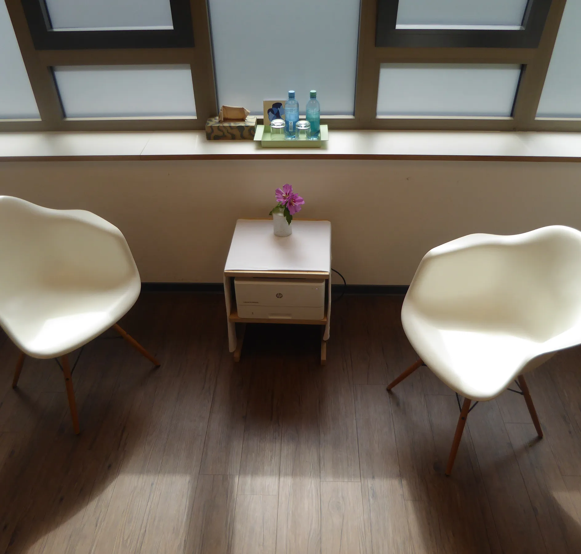 Minimalistischer, sauberer Therapieraum mit zwei Stühlen