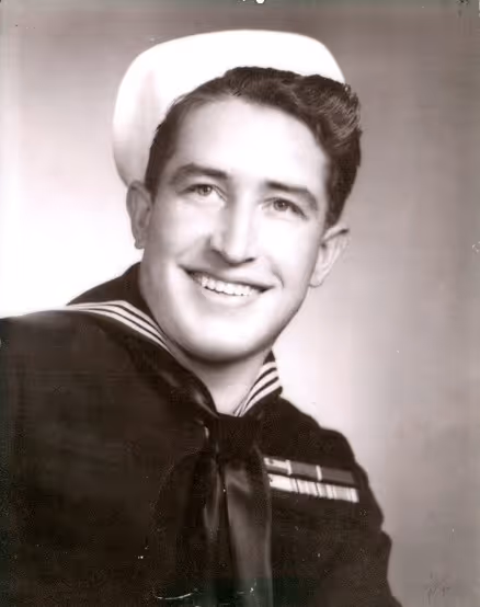 Smiling young man in vintage navy uniform and sailor hat.