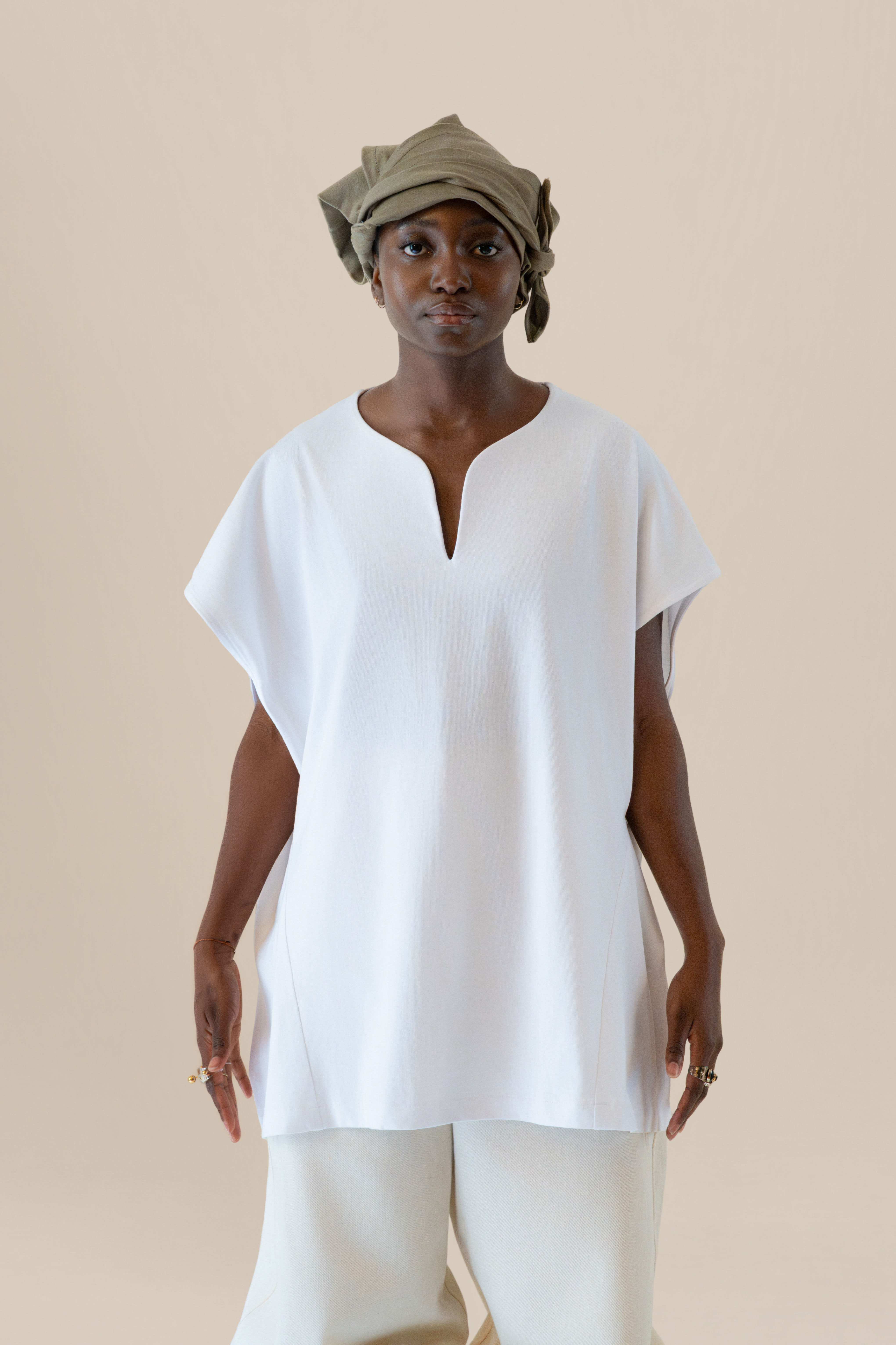 Model wearing white U-neck tunic in soft cream light, Oniri editorial aesthetic