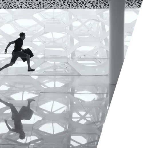 a man is running through a building with a shadow on the floor