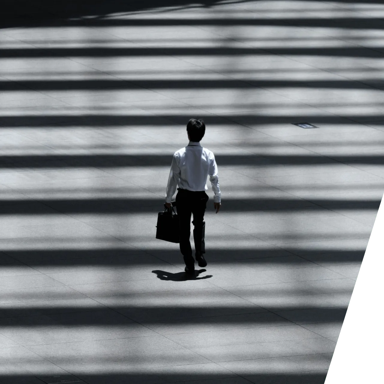 a man walking across a street holding a briefcase