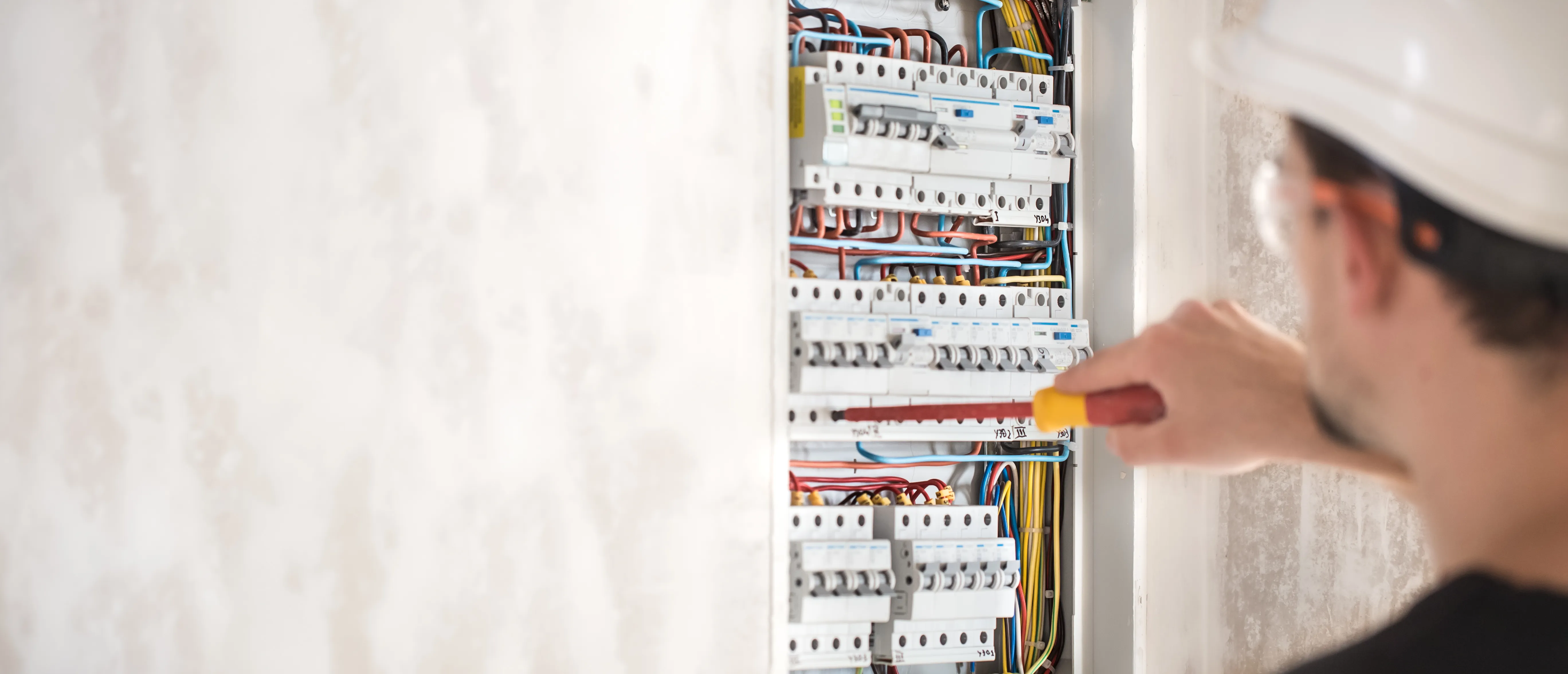 Electrical Technician working switchboard with fuses