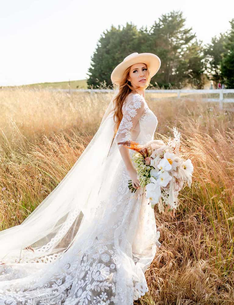 A bride posing for a photo by Let's Elope Gatlinburg in a field at her cabin in the Smokies
