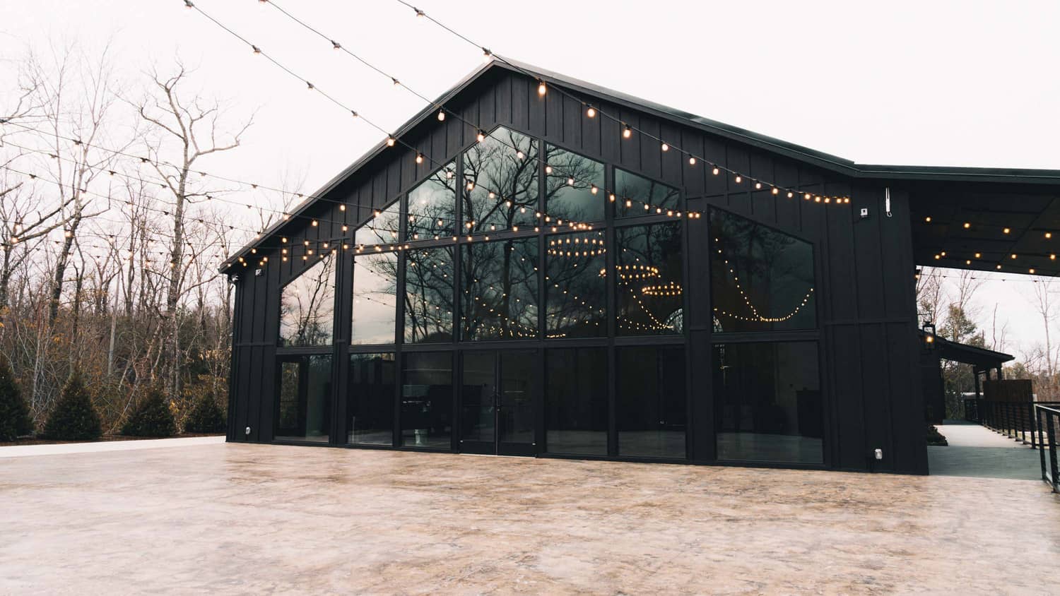 Trailhead Venues grand hall building with large glass windows, surrounded by trees, ideal for elopements in the Smoky Mountains.