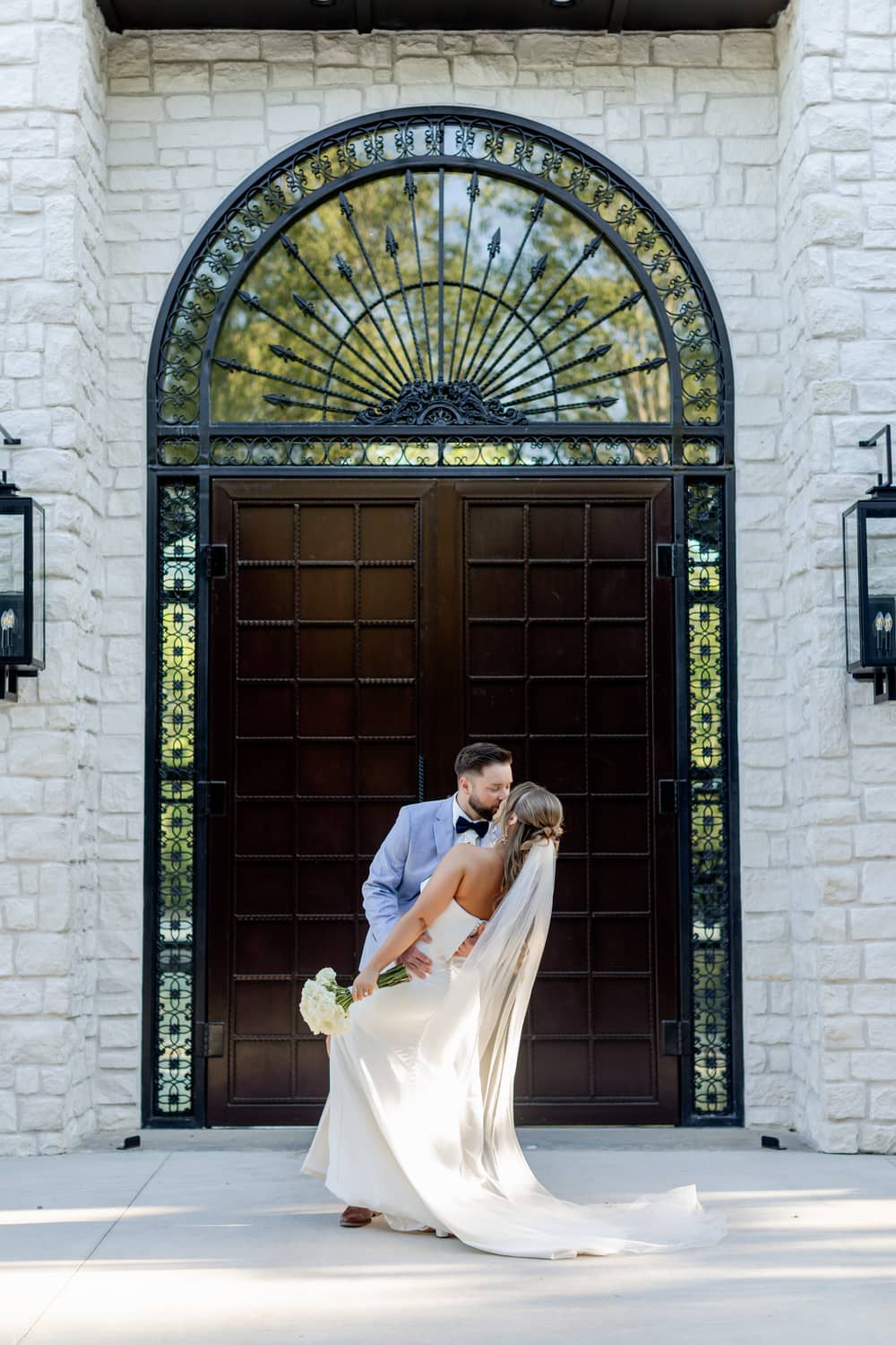 A couple embraces in front of an ornate wooden door, showcasing a romantic moment perfect for elopements in Gatlinburg.