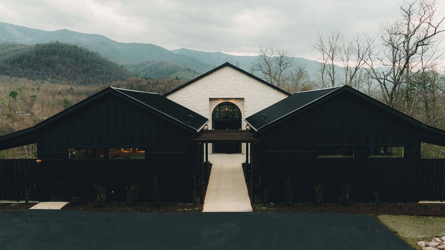 Trailhead Venues main entrance with a path leading to a central building, surrounded by mountains and trees in Gatlinburg.