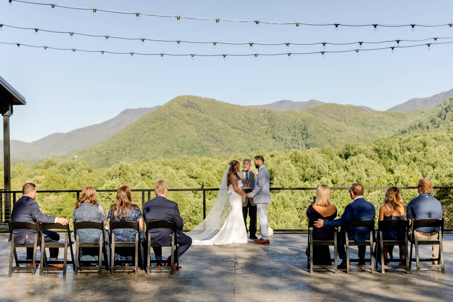 Elopement couple at Trailhead Venues exchanging vows in front of an officiant and family while overlooking the Smoky Mountains.