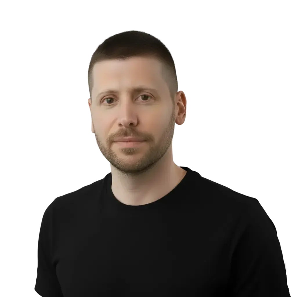 Man with short brown hair and beard wearing a black t-shirt, looking at the camera.